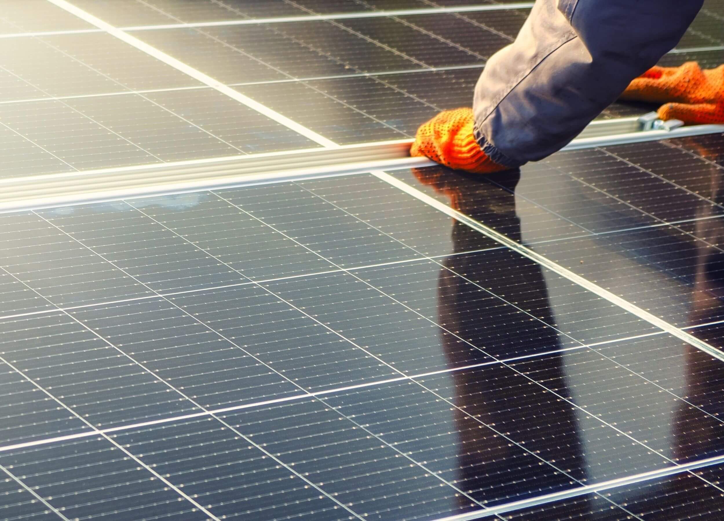 Solarpanele werden von Händen mit Handschuhen montiert